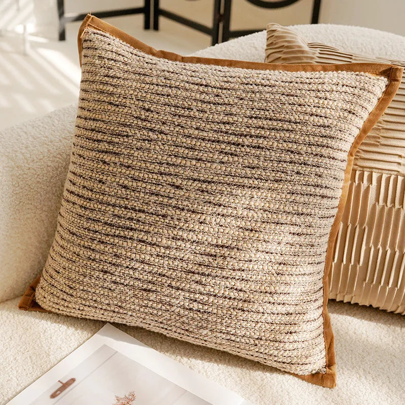 Textured beige pillow on a sofa with a blurred background