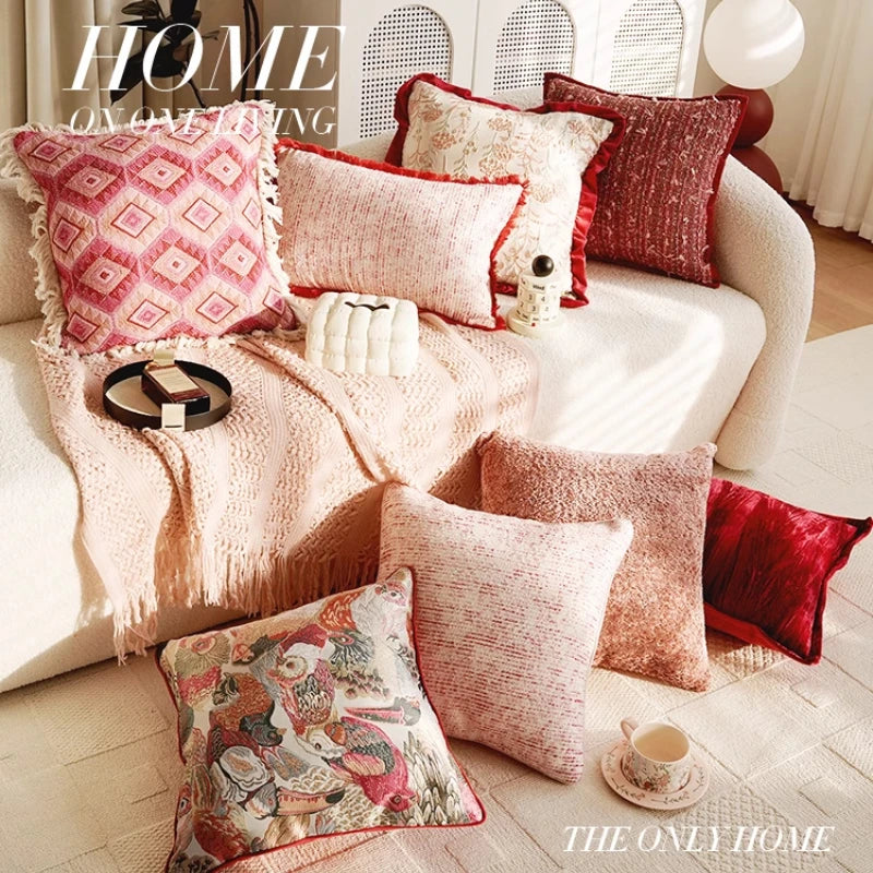 Decorative pillows on a sofa with a pink blanket and a magazine titled 'The Only Home'.
