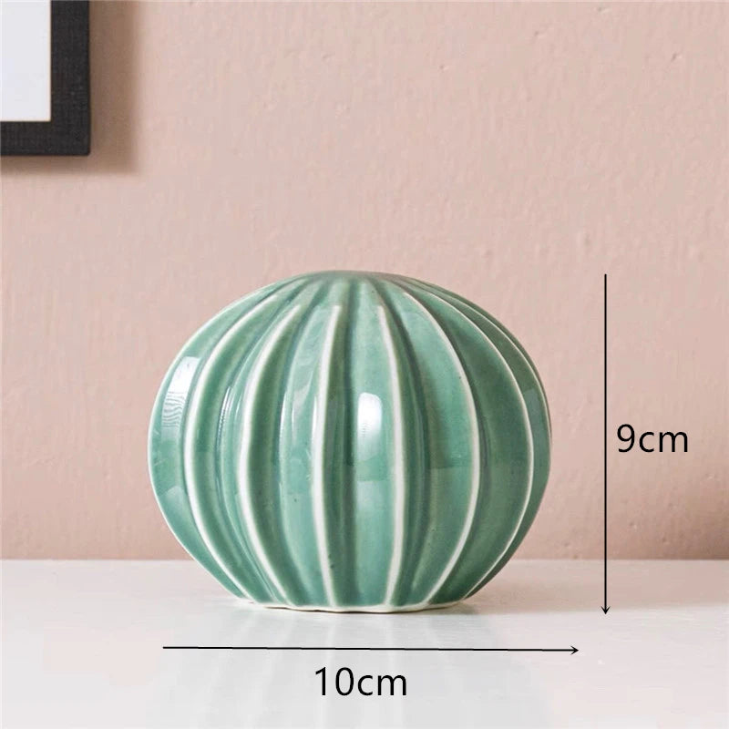 Green ceramic ball with measurements on a pink background Modern ceramic cactus figurine for home or office decoration