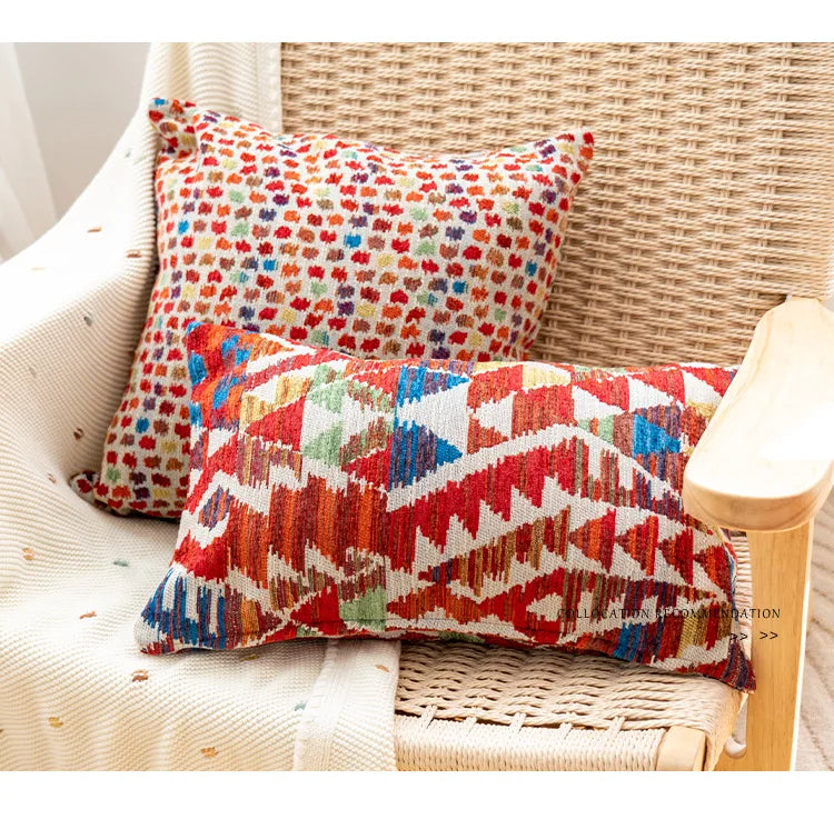 Colorful patterned pillows on a wicker chair. Bohemian Aztec woven pillow cover, geometric jacquard cushion for sofa, bed, or living room decor in neutral cotton blend fabric.