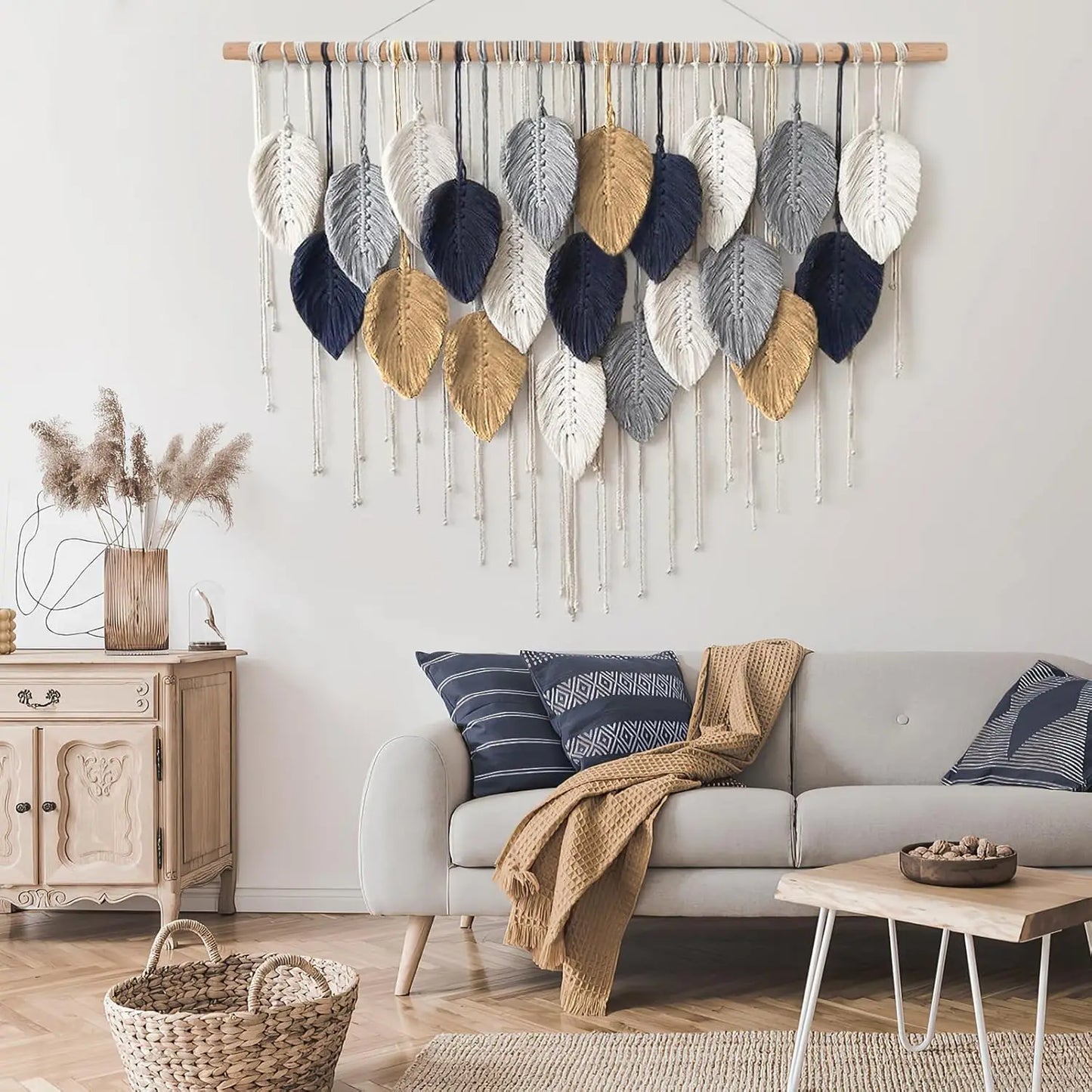 Living room with a wall hanging of knit leaves, a sofa with pillows, and a side table.