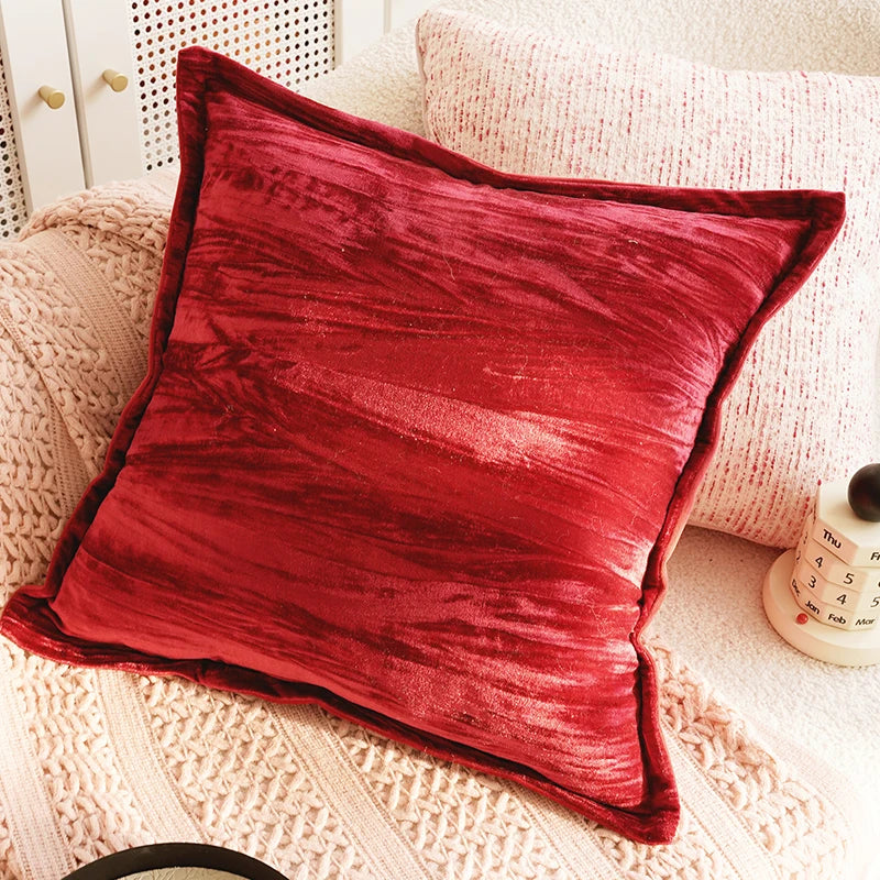 Red textured pillow on a textured surface with a blurred background. Boho Home Decor.