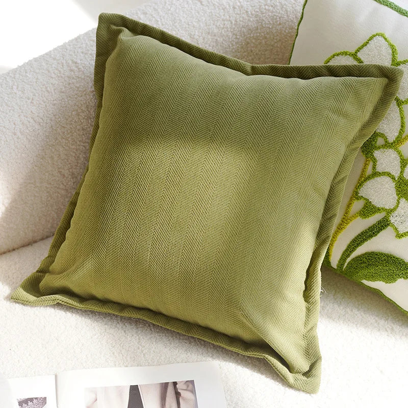 Green pillow on a sofa with a floral patterned pillow in the background Nordic lily embroidered throw pillow cover in flannel fabric, floral square cushion case for sofa, bed, and boho home decor