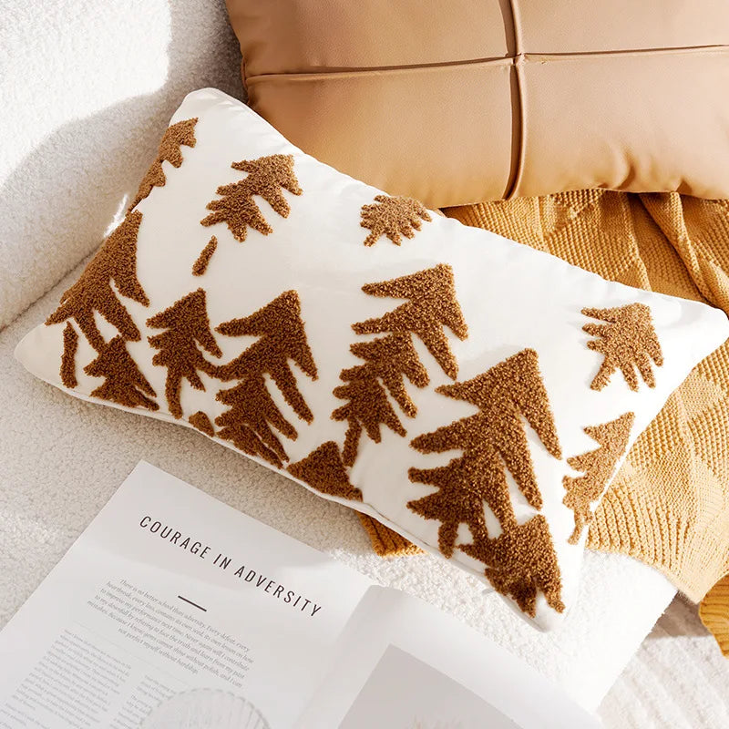 Decorative pillow with brown geometric tree pattern on a beige couch