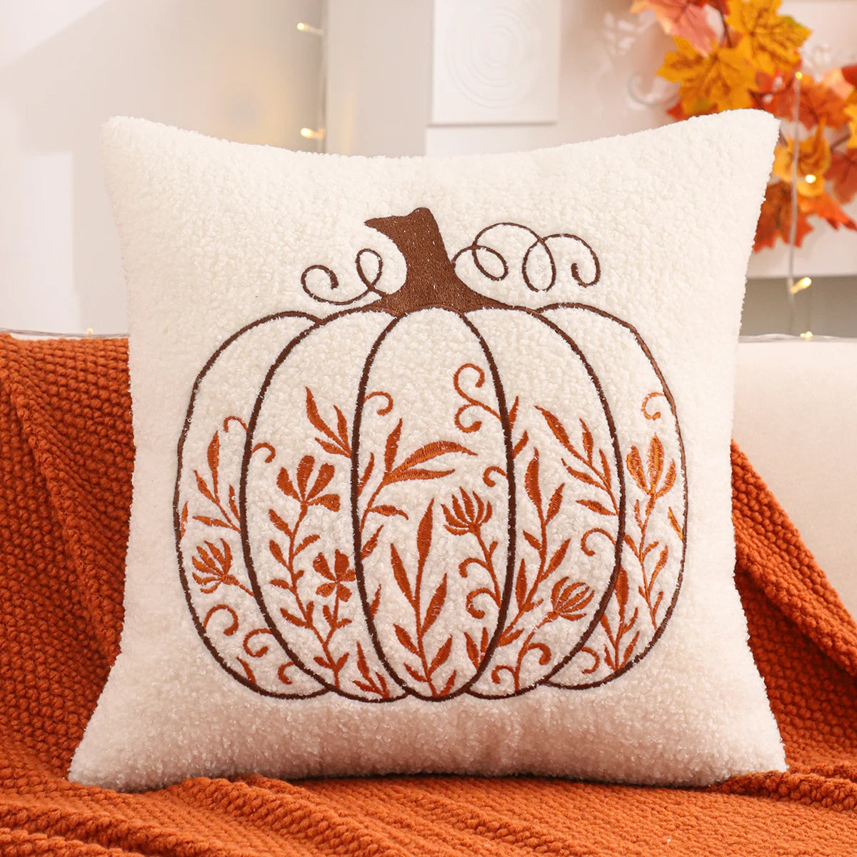 Decorative pillow with a pumpkin design on an orange surface. fall boho pillow throw gift ideas