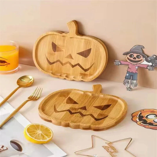 Wooden pumpkin-shaped cutting boards with Halloween-themed decorations on a table. Wooden Halloween serving tray in pumpkin and ghost shapes, rustic snack and dessert plate for party décor and fall entertaining
