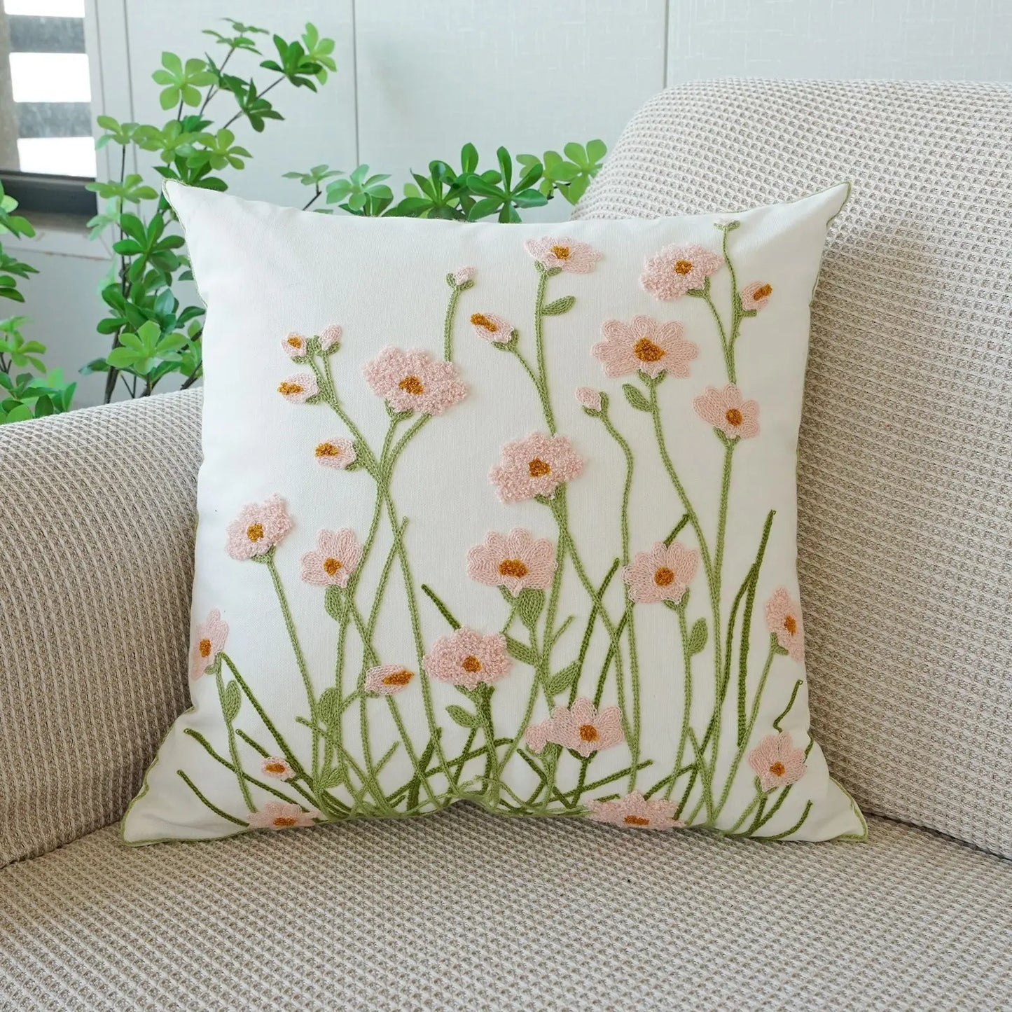 Floral-patterned pillow on a beige couch with plants in the background. Floral embroidered throw pillow cover boho decor