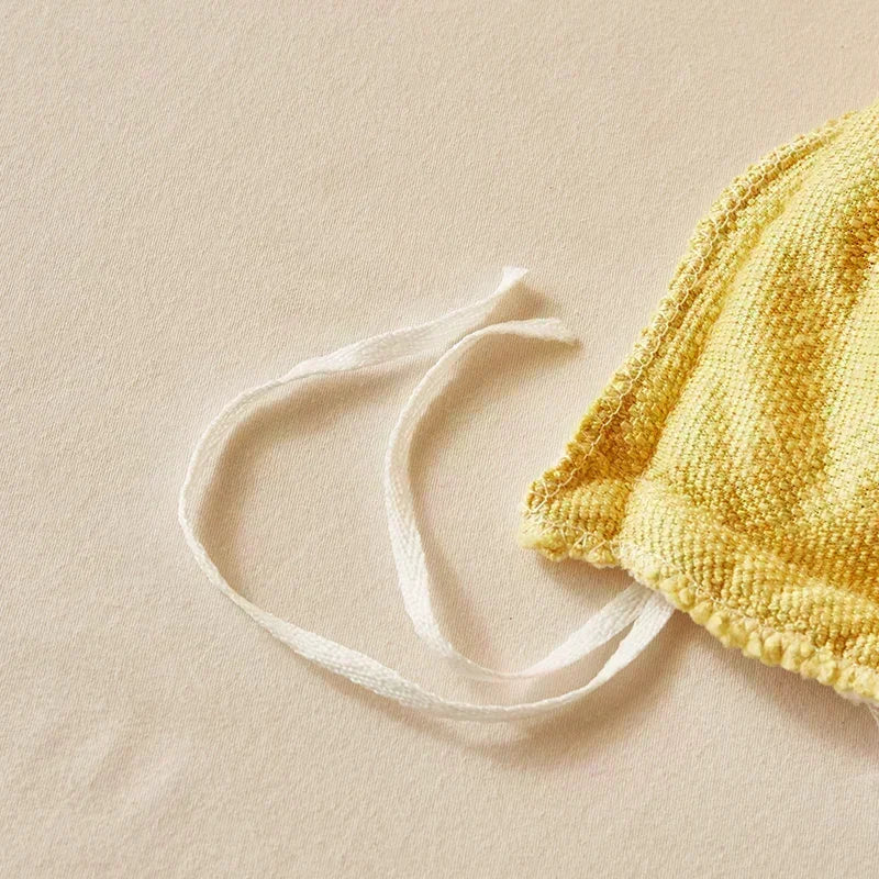 Yellow textured bag with a white strap on a beige background. Soft plush duvet cover and blanket in solid color with striped jacquard design, dual-use artificial cashmere fleece bedding for cozy winter warmth
