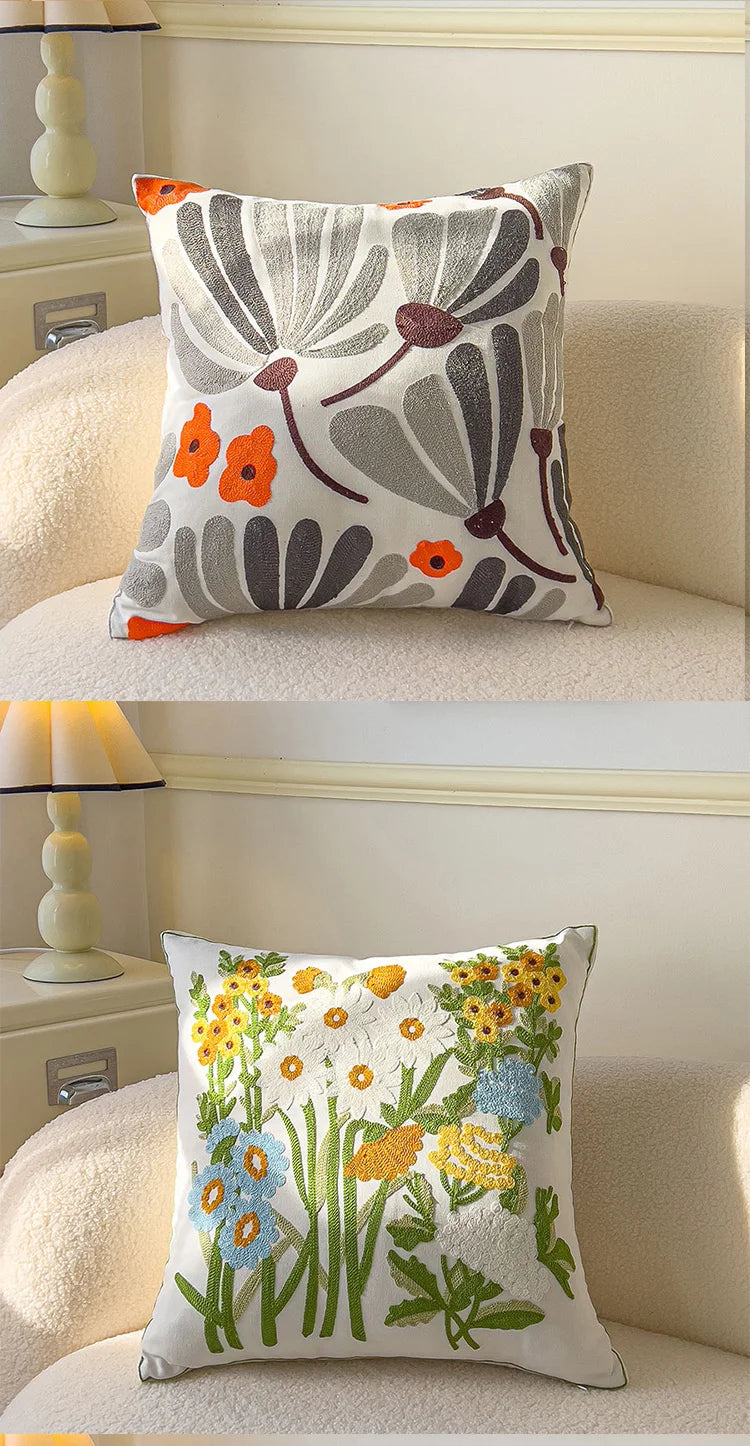 Two decorative pillows with floral patterns on a beige sofa.