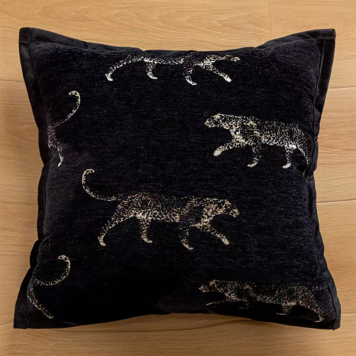 Black pillow with silver tiger patterns on a wooden surface. embroidery throw pillow cover in boho modern style