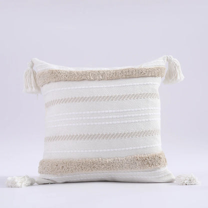 Decorative pillow with striped pattern and tassels on a light gray background