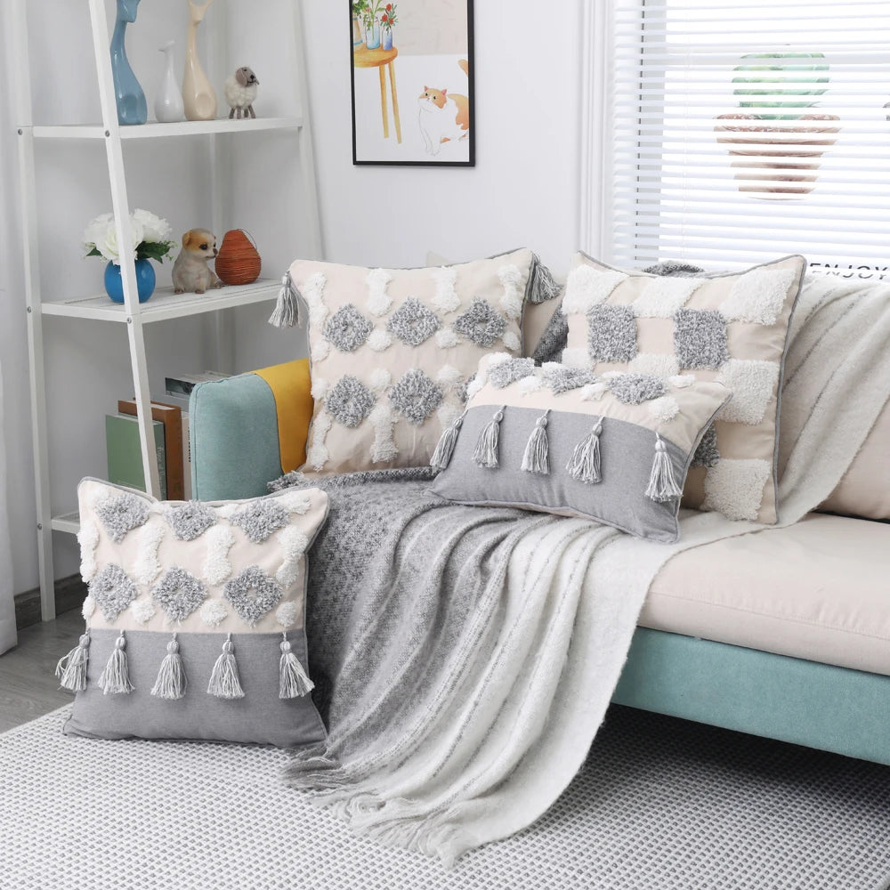 Living room with a sofa adorned with patterned cushions and a blanket, next to a white shelf.