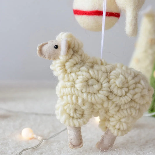 Toy sheep Christmas ornament made of yarn on a light background
