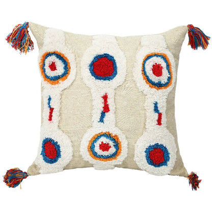 Decorative pillow with colorful circular patterns and tassels on a beige background