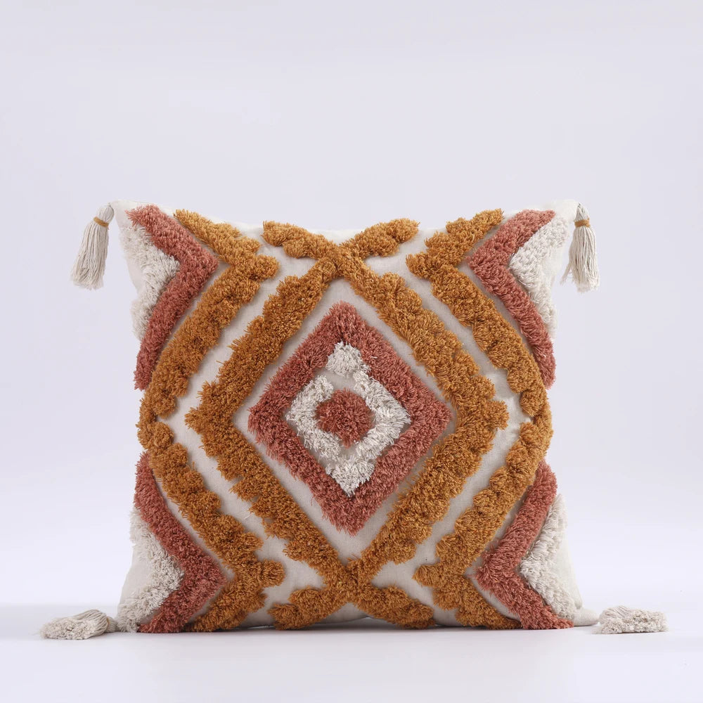 Decorative pillow with geometric pattern and tassels on a white background