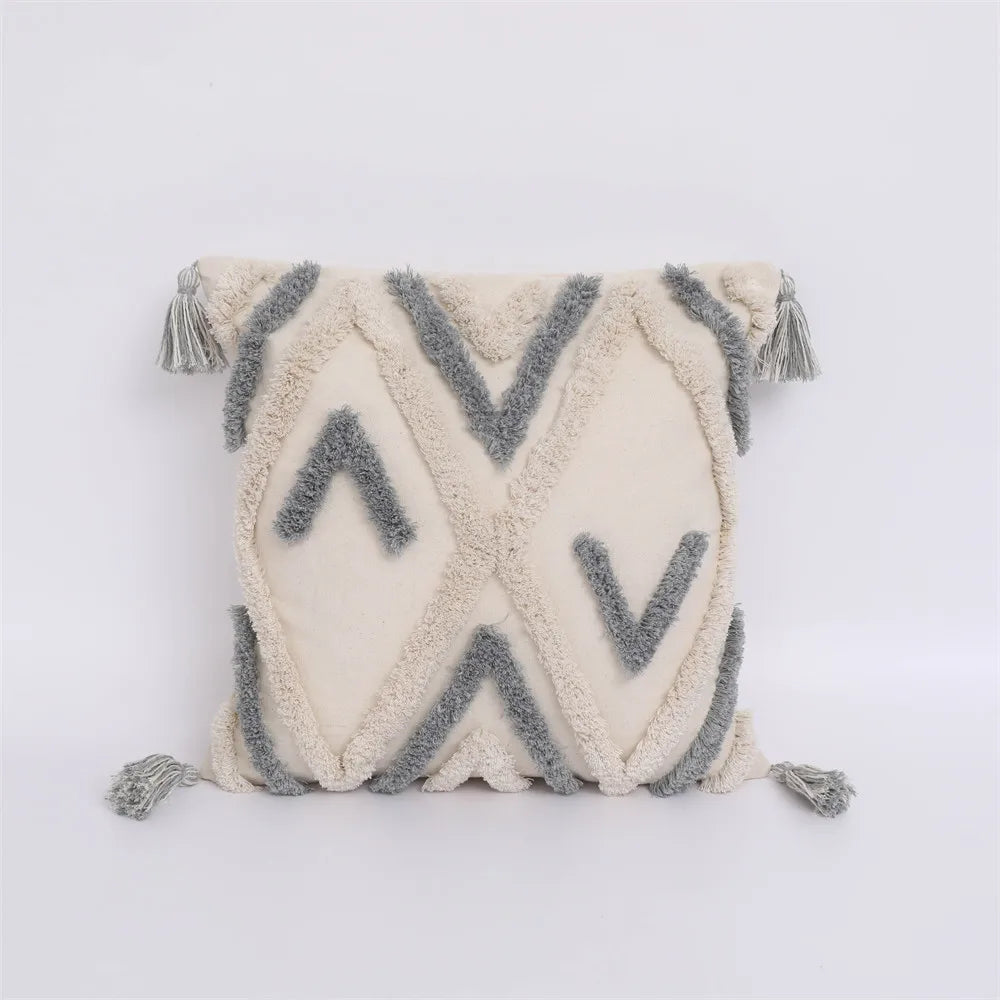 Decorative pillow with geometric pattern and tassels on a white background