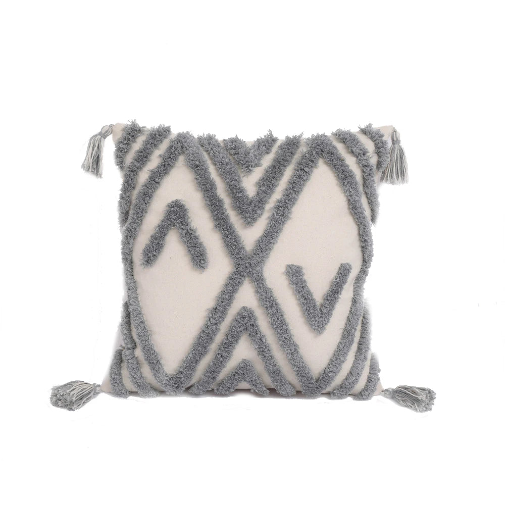 Decorative pillow with geometric pattern and tassels on a white background