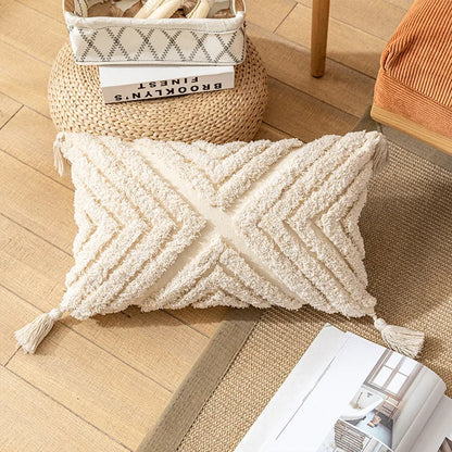 Beige textured pillow on a wooden floor with a basket and books in the background