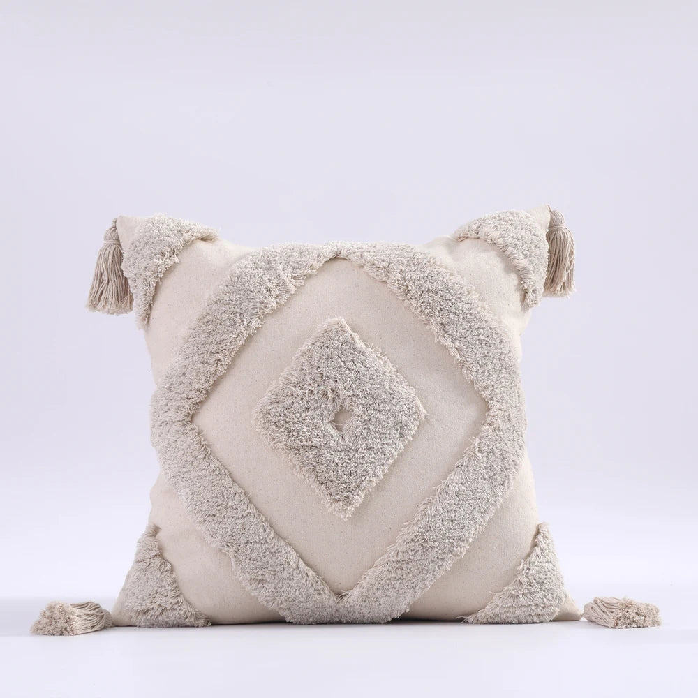 Decorative pillow with geometric pattern and tassels on a light gray background