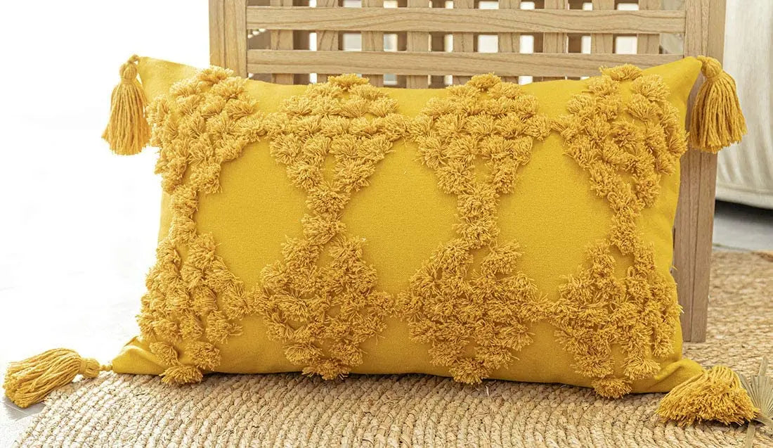 Yellow pillow with tassels on a wooden chair