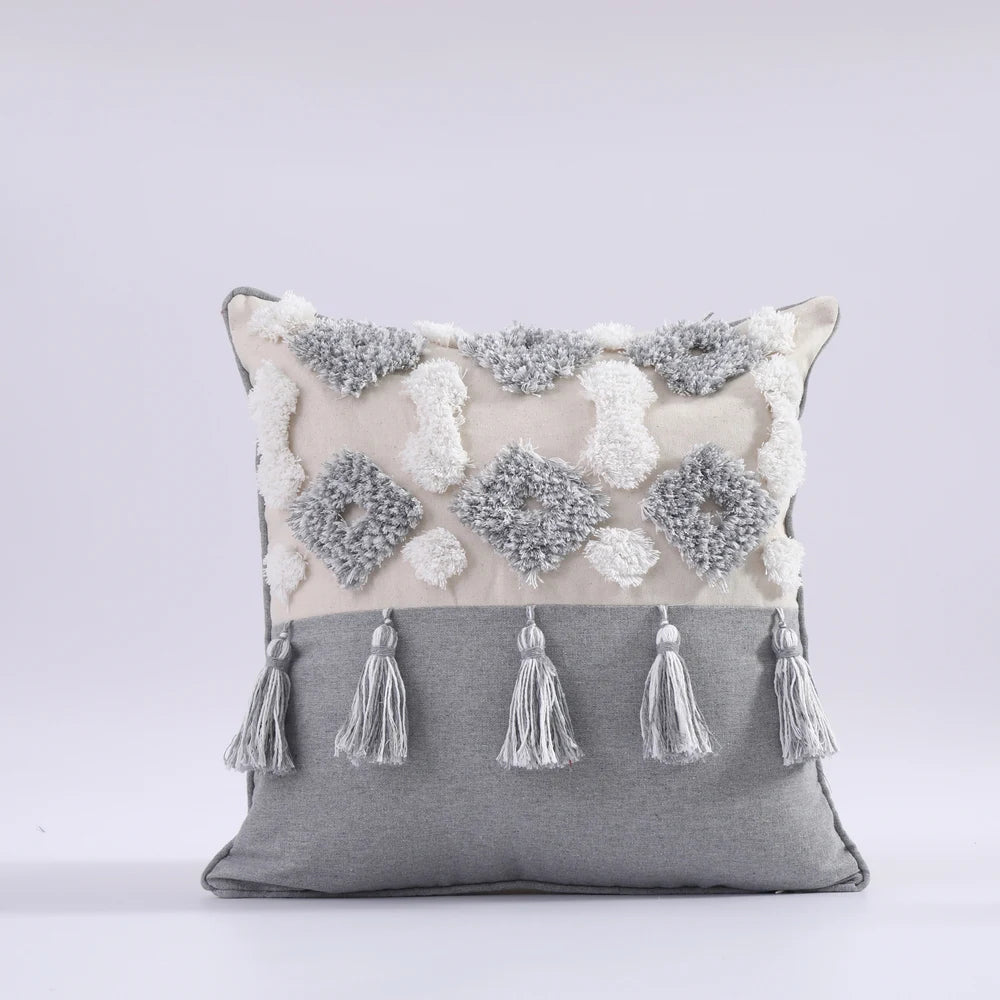 Decorative pillow with floral patterns and tassels on a gray background