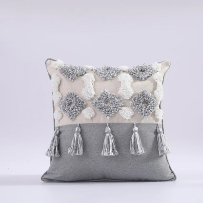 Decorative pillow with floral patterns and tassels on a gray background