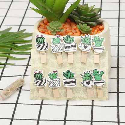 Set of cactus-themed wooden clips on a card with succulents in the background.