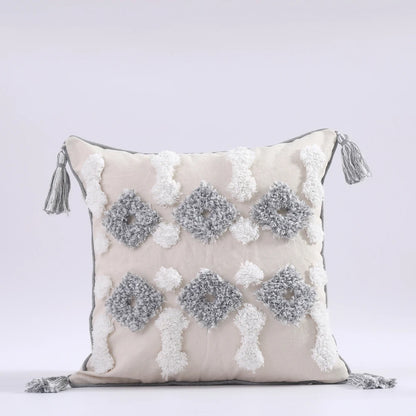 Decorative pillow with pom-pom pattern and tassels on a light gray background