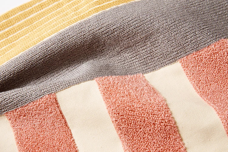 Close-up of a textured fabric with multicolored stripes. Colorful abstract geometric embroidered cushion cover in cotton blend, decorative pillowcase for living room, kids’ room, or boho home decor.