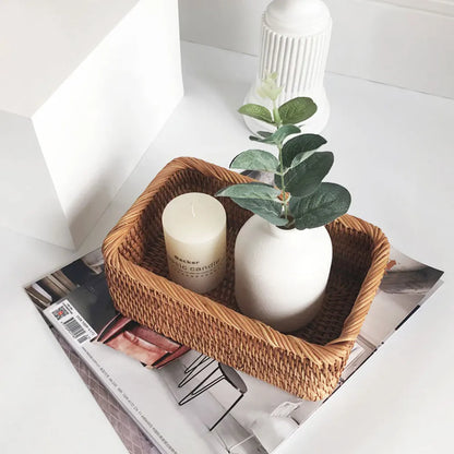 Wicker basket with a candle and plant on a magazine boho home decor, rattan basket, handwoven wicker basket, fruit storage box, bread basket, picnic basket, natural storage bin, tea storage box, rustic home organization, farmhouse decor, housewarming gift, boho storage basket