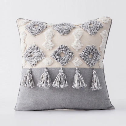 Decorative pillow with tassels and floral patterns on a white background