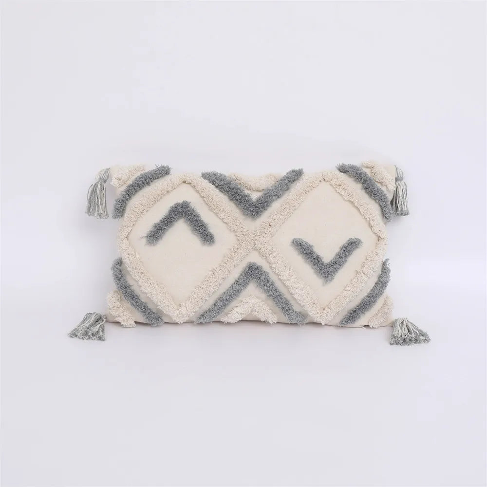 Decorative pillow with geometric pattern and tassels on a white background