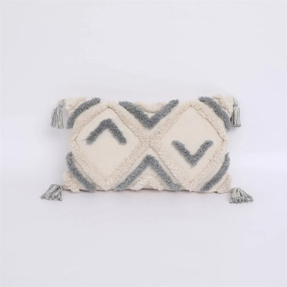 Decorative pillow with geometric pattern and tassels on a white background