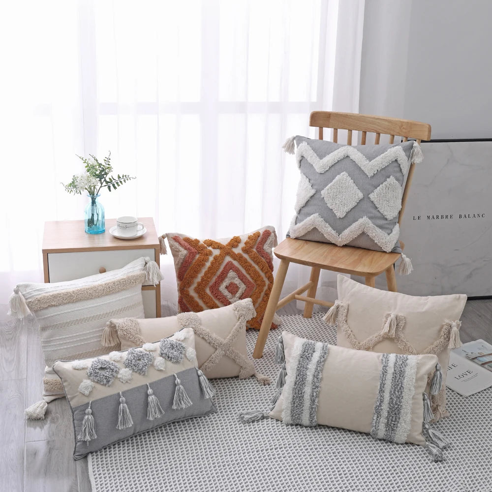 Decorative pillows on a bed with a chair and side table in the background