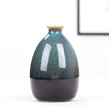Ceramic blue boho vase with speckled design on a white background