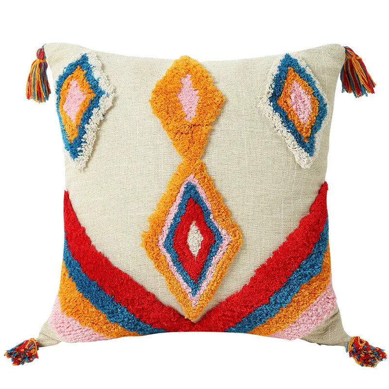 Decorative pillow with colorful geometric pattern and tassels on a beige background