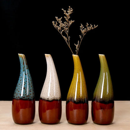 Four mini boho ceramic vases with gradient colors on a wooden surface and black background