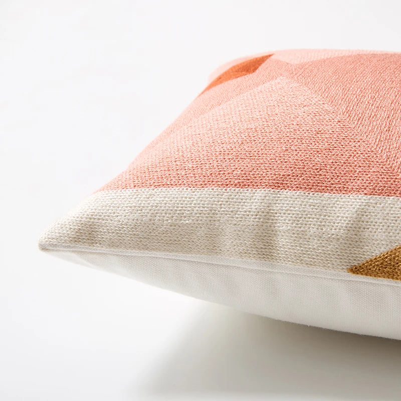 Close-up of a textured pillow with a geometric pattern on a light background Colorful abstract geometric embroidered cushion cover in cotton blend, decorative pillowcase for living room, kids’ room, or boho home decor.