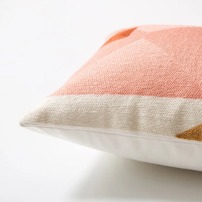 Close-up of a textured pillow with a geometric pattern on a light background Colorful abstract geometric embroidered cushion cover in cotton blend, decorative pillowcase for living room, kids’ room, or boho home decor.