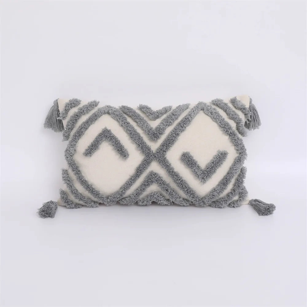 Decorative pillow with geometric pattern and tassels on a white background