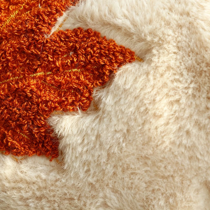 Close-up of a textured faux fur surface in warm cream with a prominent burnt orange shaggy accent on the left side.