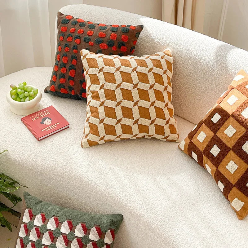 Decorative pillows on a white sofa with a small plant and book. Bohemian embroidered throw pillow cover 18x18 inch with geometric towel embroidery, decorative cushion for sofa, bed, or living room boho home decor