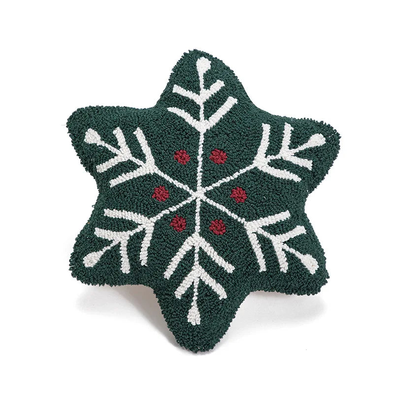 Star-shaped green cushion with white snowflake design and red centers on a white background
