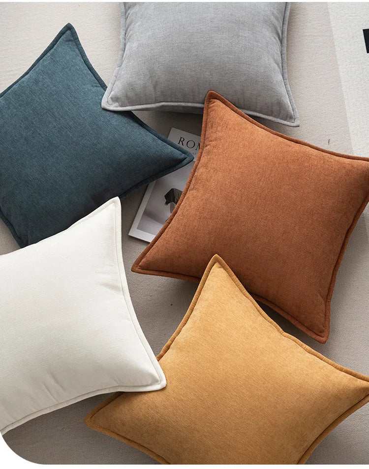 Colorful pillows on a sofa with a magazine underneath