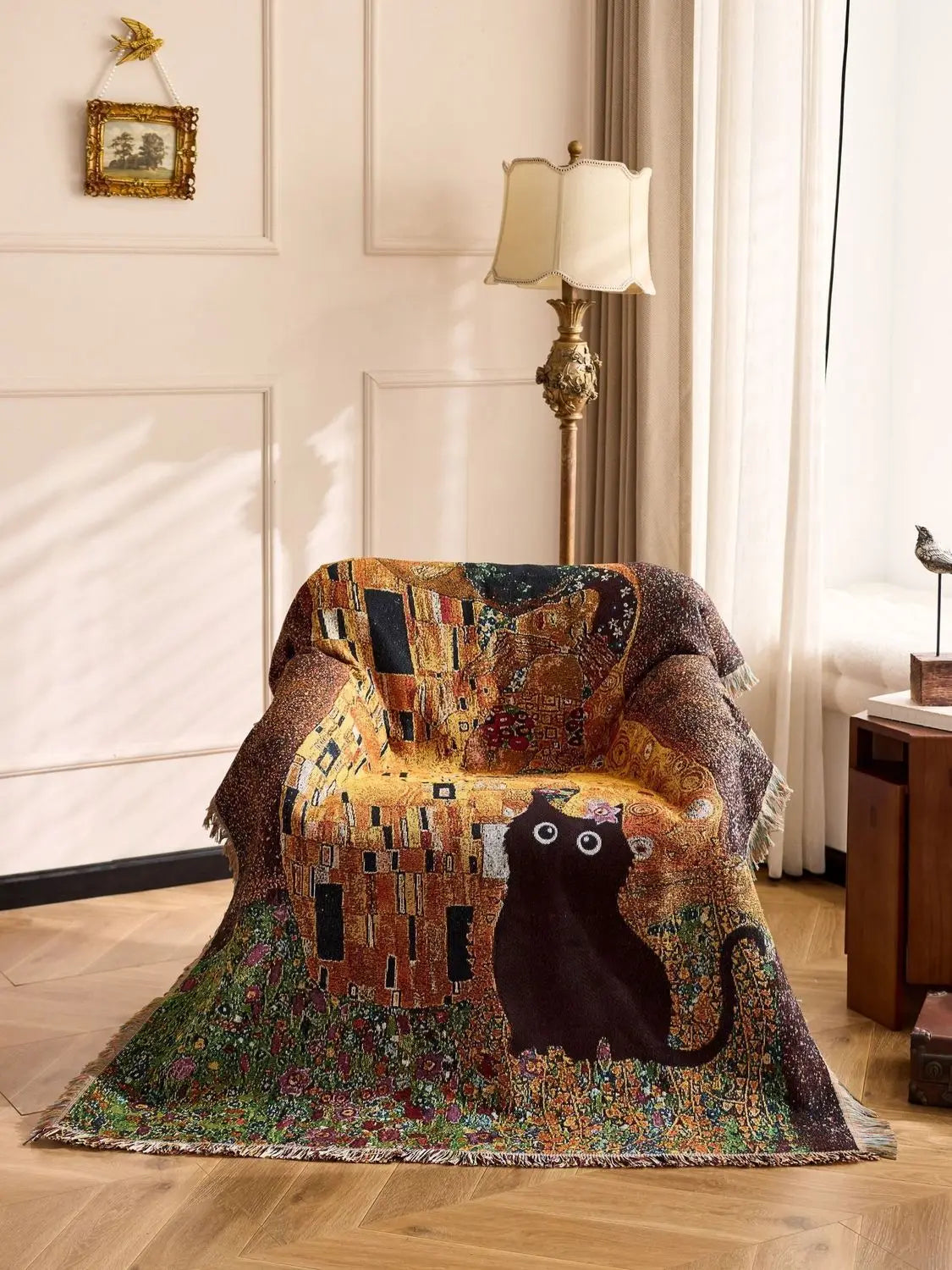 Decorative blanket with a cat design draped over a chair in a room with a lamp and framed picture. Cat woven throw blanket for boho sofa and home decor