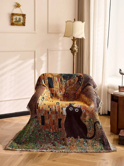 Decorative blanket with a cat design draped over a chair in a room with a lamp and framed picture. Cat woven throw blanket for boho sofa and home decor