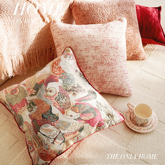Decorative pillows on a sofa with a cup and saucer, featuring 'The Only Home' brand.