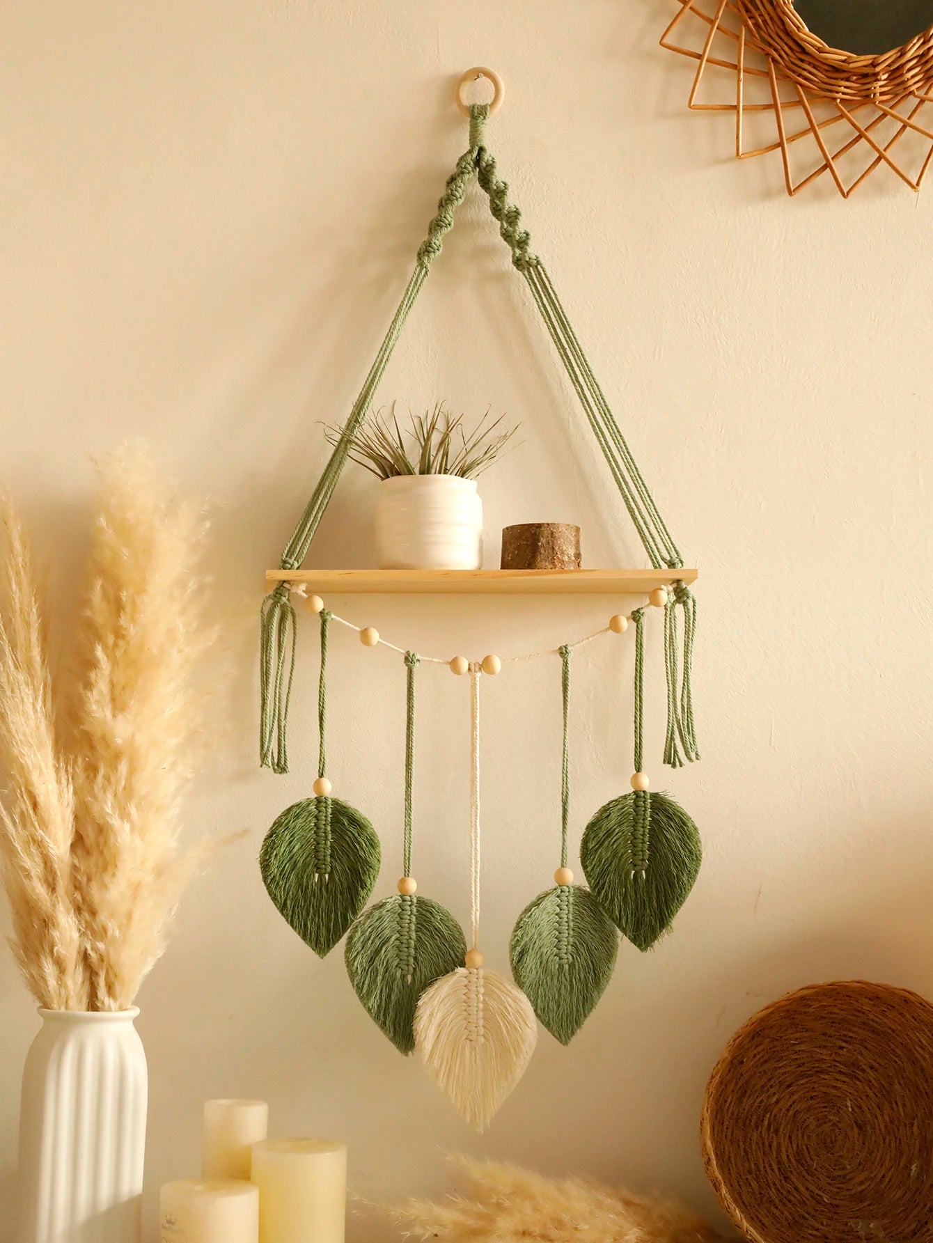Hanging shelf with macrame leaf decorations on a neutral wall