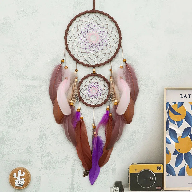 Dreamcatcher with feathers hanging on a wall next to a camera and framed picture. boho home decor, housewarming gift, dream catcher wall hanging, feather wind chime, handmade dreamcatcher, colorful boho wall decor, birthday gift decor, modern bohemian style, bedroom hanging ornament, spiritual home decor, dreamcatcher nursery decor