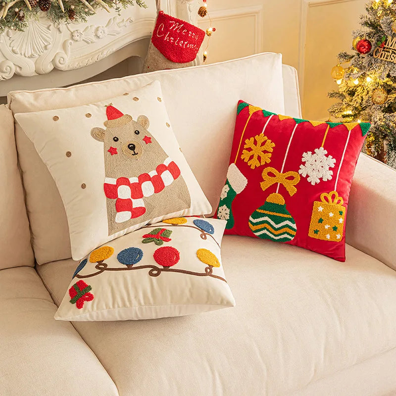 Decorative Christmas pillows on a couch with a festive background.